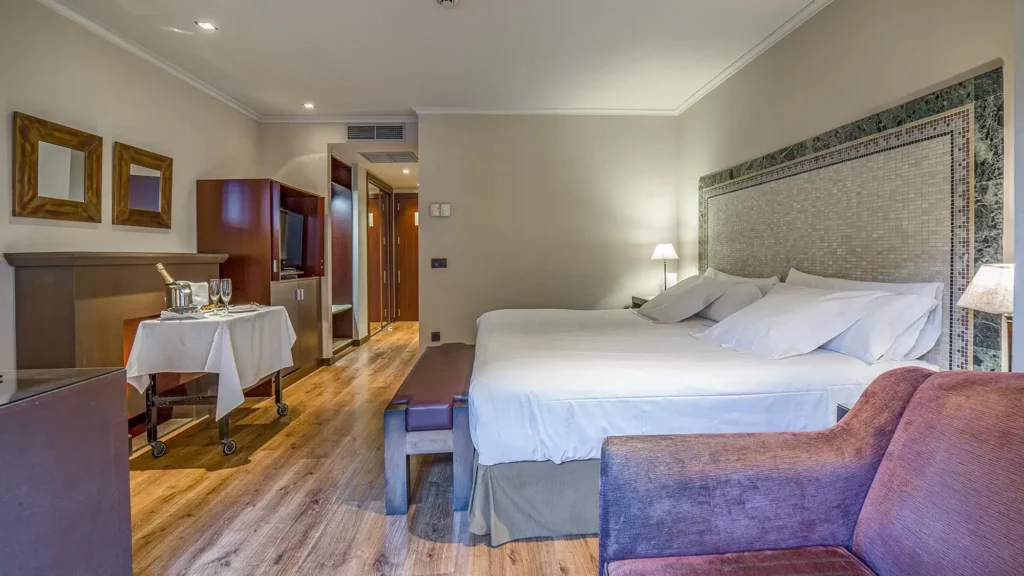 big double room with double bed, chair, desk and roomservice - deluxe room- roc blanc hotel & spa andorra