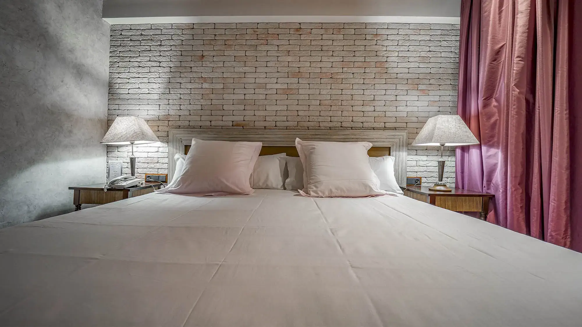 double room with double bed brick wall and purple curtains - deluxe room- roc blanc hotel & spa andorra