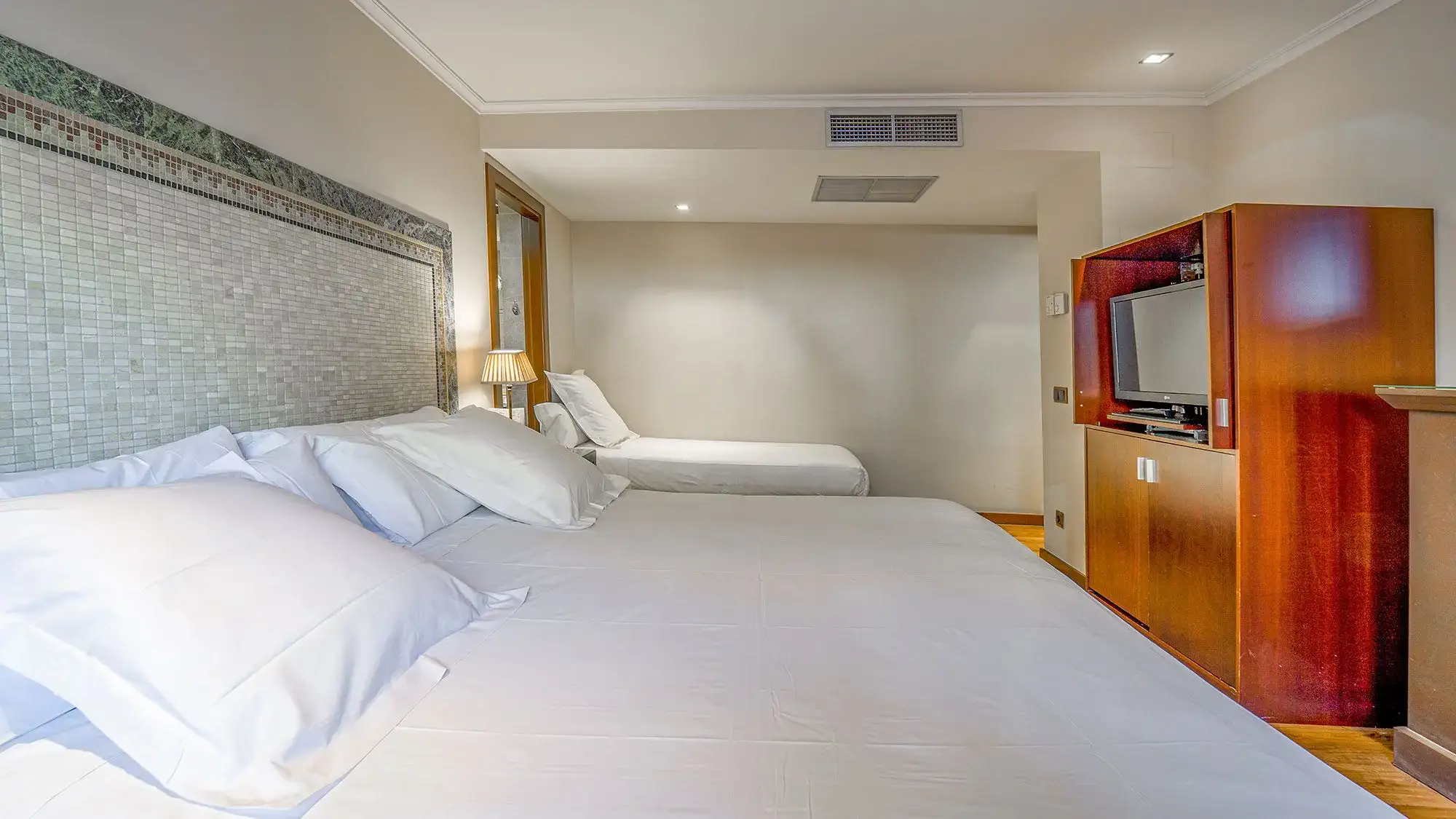 room with double bed and an additional single bed - deluxe room- roc blanc hotel & spa andorra