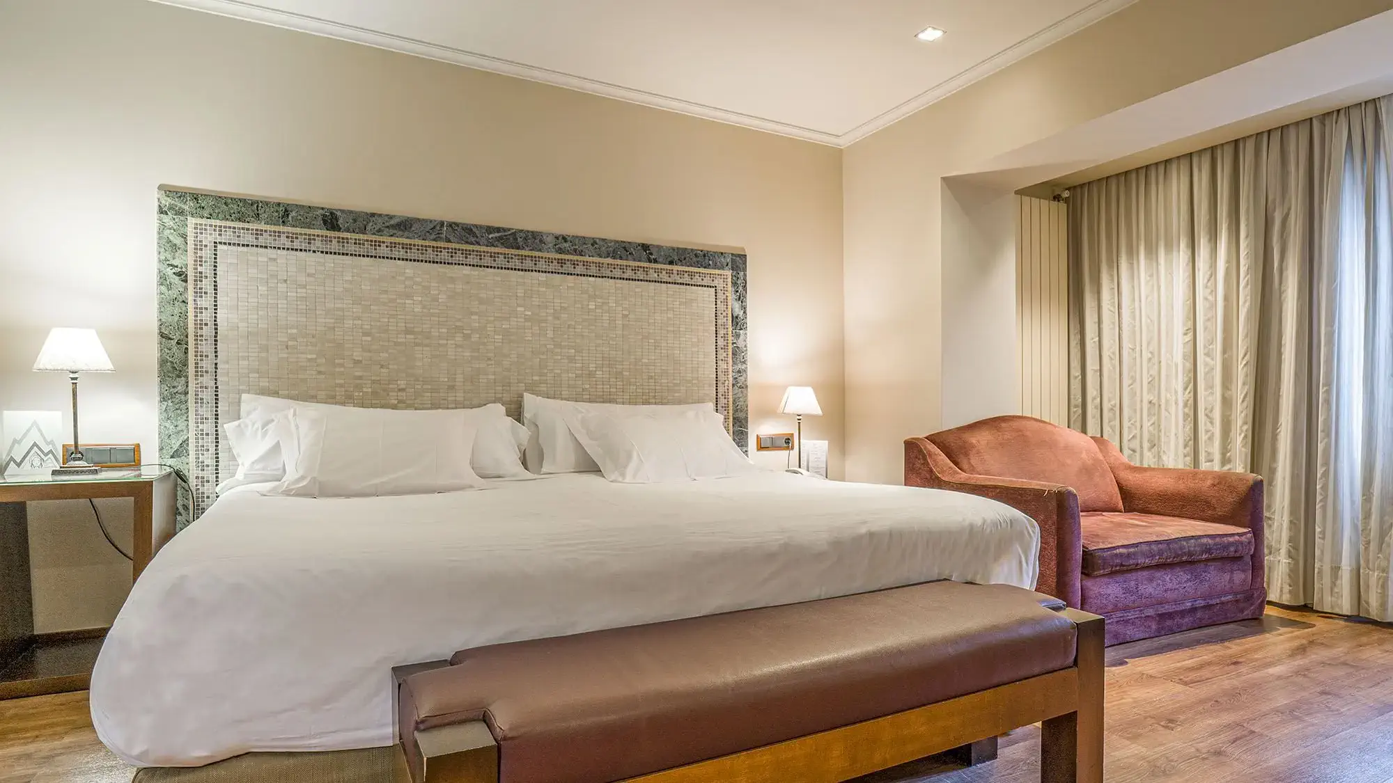 habitación con cama doble, banco y silla - roc blanc hotel & spa andorra