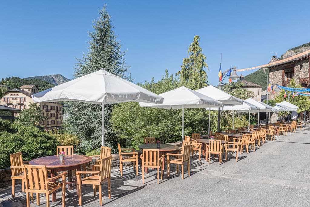 Terraza del Restaurante Topic, ubicado en Ordino con mesas y parasoles con vistas al centro de la ciudad.